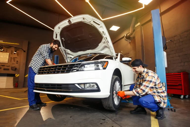 smiling-mechanics-repairing-modern-car-workshop